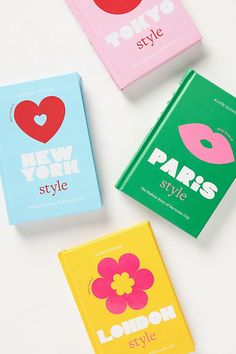 three new york style books are shown on a white surface, one is pink, the other is blue