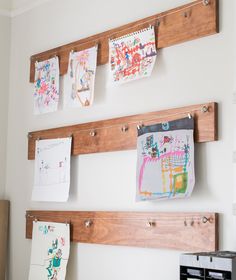 kids'art gallery hanging on the wall with pegs and magnets attached to it