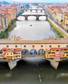 an aerial view of a bridge over a body of water with buildings on both sides