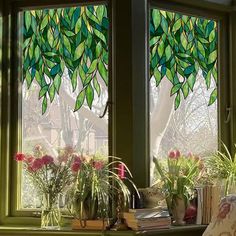 two green stained glass windows with plants in them