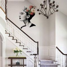 the staircase is decorated with flowers and an image of a woman's face on the wall