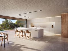 an open kitchen and dining area with large windows