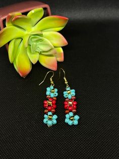 Red & Blue Beaded Flower Earrings * About the product  Drop length: about 1 1/2 inches long Colors: red & blue  Materials: bead * This one of a kind pair of earrings would be perfect to bring a smile to your friends and family. It is lightweight and fashionable. It's the perfect gift for family members or friends. * Contact and Follow Us!  If you have any questions about this pair of earrings feel free to message us on Etsy. We will be happy to answer them.  Shop our store:  https://www.etsy.com/shop/Toparadiseandbeyond Facebook: https://m.facebook.com/To-Paradise-And-Beyond-194702878032699/ Instagram: https://www.instagram.com/toparadiseandbeyondco/ Adjustable Red Flower Beaded Earrings, Blue Flower Earrings With Colorful Beads As Gift, Gift Blue Flower Earrings With Colorful Beads, Red Beaded Dangle Flower Earrings, Red Dangle Flower Earrings With Colorful Beads, Red Beaded Flower Earrings, Red Flower Dangle Earrings With Colorful Beads, Handmade Red Flower Earrings With Round Beads, Blue Flower-shaped Earrings With Colorful Beads