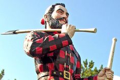 a statue of a man holding a baseball bat and wearing a red and black checkered shirt