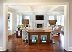 a living room filled with furniture and a fire place in the middle of a room