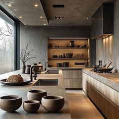 a modern kitchen with wooden cabinets and counter tops, along with bowls on the counter