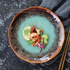 a plate with some food on it next to chopsticks