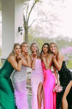 four beautiful women posing for the camera in their evening gowns, one with her hand on her hip