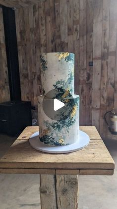 a white and blue cake sitting on top of a wooden table