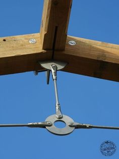 an overhead view of a wooden structure with two circular metal objects hanging from it's sides