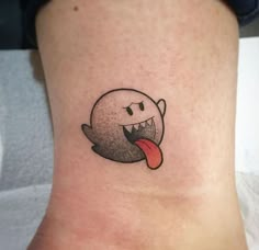 a small tattoo on the ankle of a woman's leg with a tongue sticking out