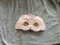 a paper owl mask on top of a towel