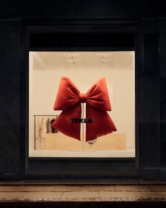 a store window with a red bow on it