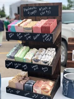 three tiered display with different types of soaps on it's sides at an outdoor market