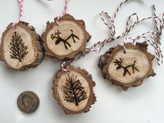 three ornaments made out of tree slices and twine with string on them next to a penny