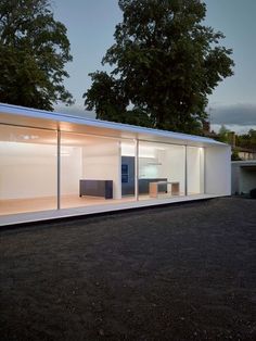 a house that is sitting on the ground with glass walls and doors in front of it