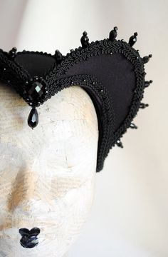 This is a purple and black version of one of most successful designs called Countess. This vampire style headdress is covered with dark purple taffeta and embellished with black cord trimming all around the edges.It is further trimmed with black crystal details that create a halo effect as well as small l beads that were hand-sewn on the trimming to create rich textural interest. The piece is completed with a black crystal handmade element placed at the center front for all that extra drama that Elegant Halloween Theater Costumes, Handmade Black Headpiece For Costume, Medieval Black Halloween Costume, Medieval Fitted Costume For Festivals, Fitted Medieval Festival Costume, Gothic Costume Hats For Masquerade And Carnival, Gothic Costume Hats And Headpieces For Masquerade Carnival, Handmade Costume Accessories For Halloween Masquerade, Handmade Gothic Costume Hats And Headpieces