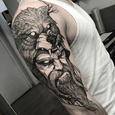 a man's arm with a black and white tattoo of a wolf on it