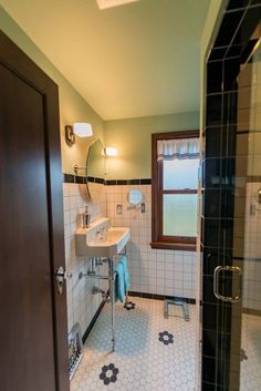 a bathroom with a sink, mirror and shower stall in the middle of it's tiled floor