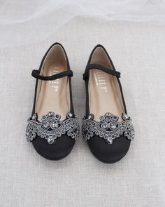 a pair of black high heel shoes with crystal embellishments on the toes