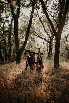 three witches standing in the middle of a forest