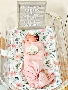 a baby is laying in a plastic container with a sign on it's side