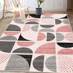 an area rug with various shapes and colors on the floor in front of a chair