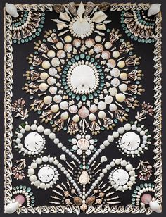 an intricately designed black and white wall hanging with shells, pearls, and beads