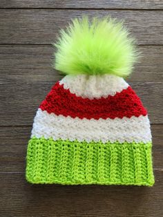 a crocheted hat with a green pom - pom