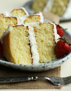 a white plate topped with slices of cake and strawberries