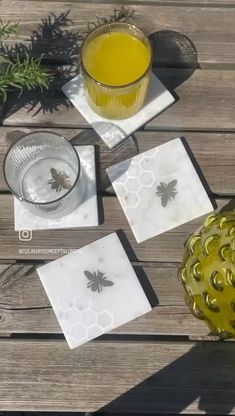 the table is set with bee coasters and a glass of orange juice on it