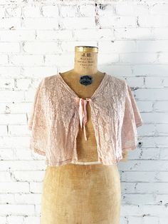 Sweet c. 1930s lace cape / bed jacket Rosette pattern tan lace V-neck Ties in front with pink satin ribbon Label: Haynes Textile Co. Mount Airy, NC. Large. Bed Jackets, Rosette Pattern, Ribbon Label, Lace Capelet, Lace Cape, Bed Jacket, Mount Airy, Neck Ties, Pink Satin