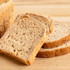 sliced bread sitting on top of a wooden cutting board next to a slice of bread