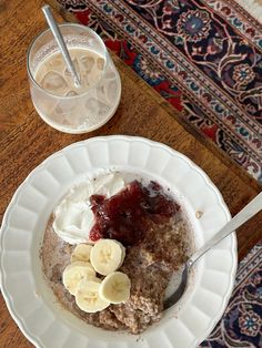 a bowl of oatmeal with banana slices and whipped cream on the side