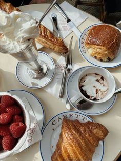 there is a croissant, ice cream and raspberries on the table