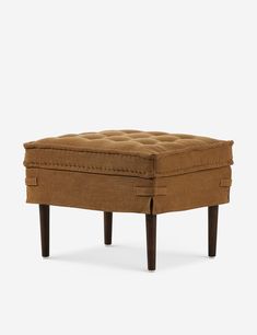 the footstool is made out of brown fabric