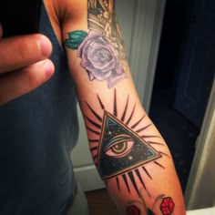 a person with a tattoo on their arm and an all seeing eye in the middle