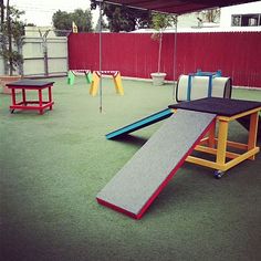 an outdoor play area with slides and swings for children to slide down the slide is painted red, yellow, blue, and green