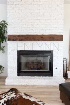 a living room with a white brick fireplace and cowhide rugs on the floor