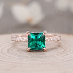 an emerald colored ring with diamonds on top