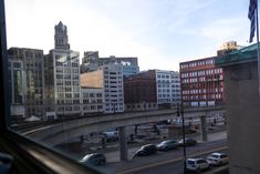 cars are parked on the side of an overpass in a city with tall buildings