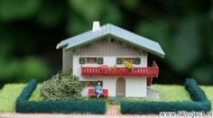 a toy house sitting on top of a green field