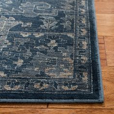 a blue area rug on the floor with wood floors and hard wood planks in the background