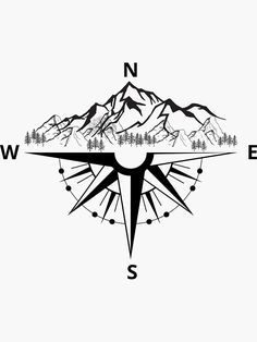 a black and white compass with mountains in the background