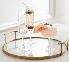 two glasses with drinks sitting on a tray