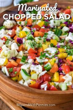 a wooden bowl filled with chopped salad and the words marinated chopped salad above it