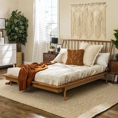 a bed sitting on top of a wooden floor in a bedroom