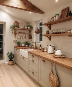 a kitchen filled with lots of counter top space and wooden shelves next to a window