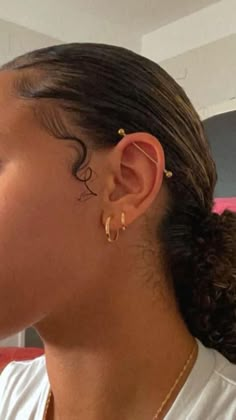 a close up of a person with ear piercings on their ears and wearing a white t - shirt