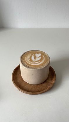 a cappuccino sitting on top of a wooden plate